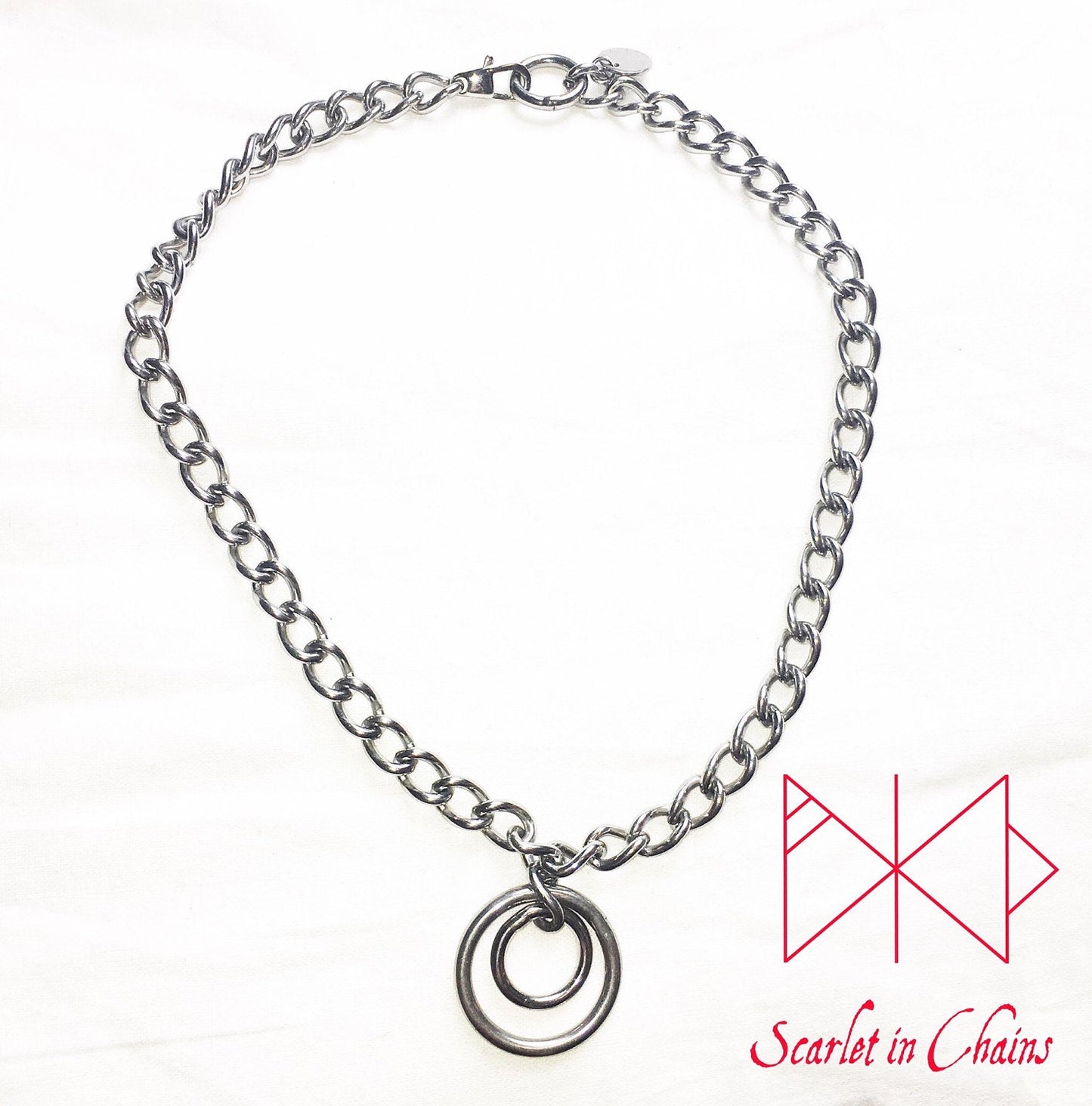 Stainless steel chain choker with a double stainless steel O ring pendant which consists of a smaller o ring inside a larger one. finished with a stainless steel clap flat shot