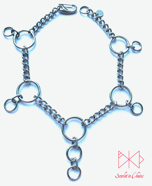 Coven mini collar flat, Stainless steel mini chain choker with 5 o rings spaced around the collar with a smaller o ring hanging from the side ones and 2 smaller o rings hanging from the central one