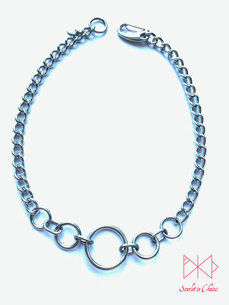 Stainless steel Luna Phase chain choker with multiple o rings in reducing sizes indicating a moon phase pattern. Shown flat with new links