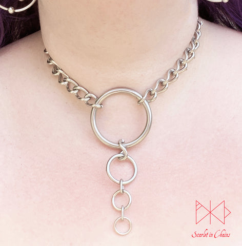 Alignment choker worn Stainless steel chain collar with central O ring with 3 smaller o rings cascading in size suspended from it shown with new links