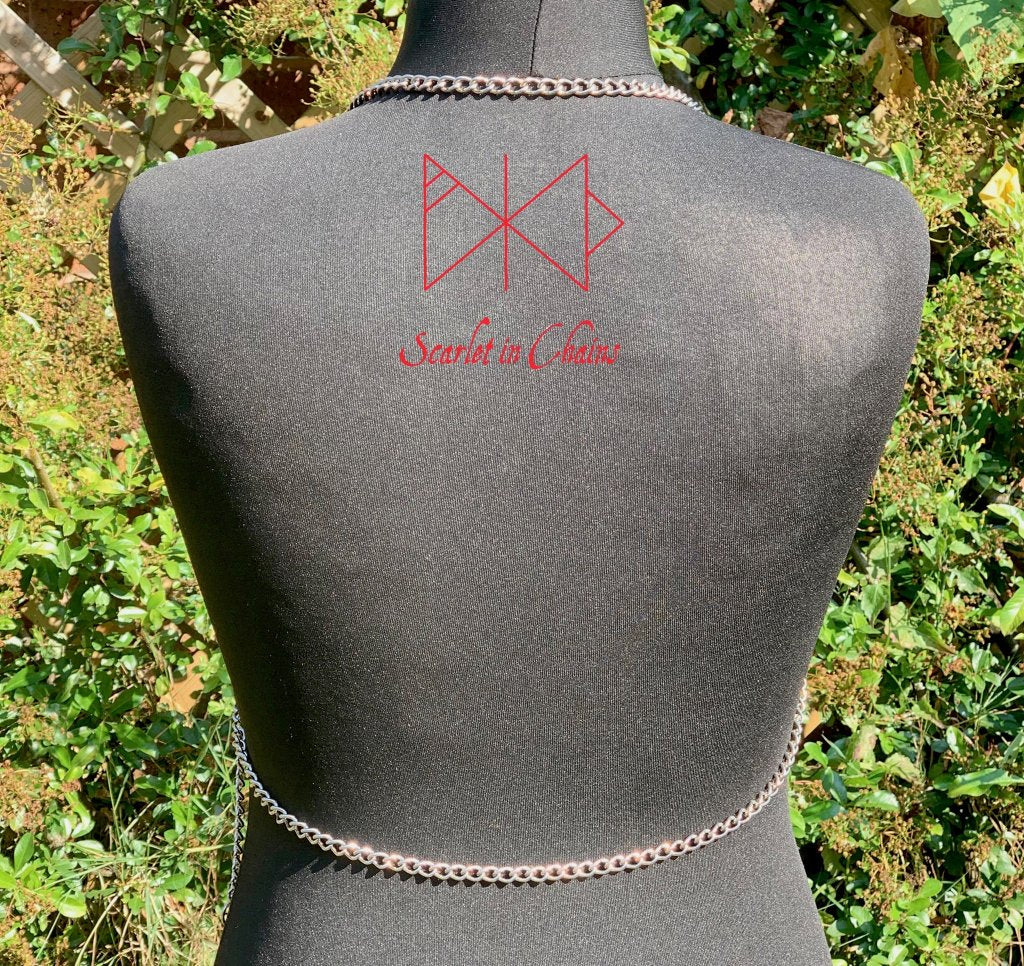 Alignment body harness, a halter-neck stainless steel chain harness. with triangular chains over the chest bikini top style. with 3 depending in size, Stainless Steel O rings. fasted with a stainless steel clasp at the waistband back view