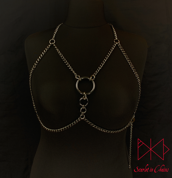 mannequin shot of Alignment body harness worn, a halternect stainless steel chain harness. with triangular chains over the chest bikini top style. with 3 depending in size, Stainless Steel O rings. fasted with a stainless steel clasp at the waistband 