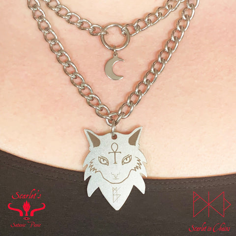 close up shot of stainless steel double layer necklace featuring a stainless steel mini crescent  on the top layer and a limited edition Sabra the cat charm on the bottom layer
