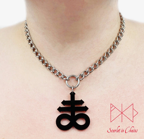 Leviathan cross choker worn by model. Stainless steel chain choker with stainless steel O ring at centre. Suspended from the O ring is a black perspex Leviathan cross charm.