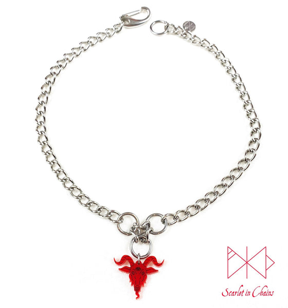 Baphomet choker necklace. A stainless steel chain choker necklace with 3 stainless steel O rings forming an inverted triangle. Hanging from the inverted triangle of O rings is a red perspex Baphomet pendant with hand finished black facial details. Necklace is closed with an easy to us stainless steel clasp. Shown flat on a white background